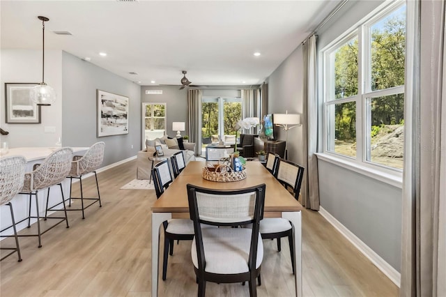 dining room with baseboards, light wood-style floors, and a ceiling fan