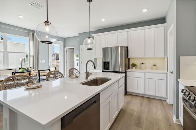 kitchen featuring a sink, light countertops, white cabinets, and stainless steel appliances