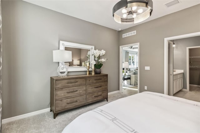 bedroom featuring visible vents, baseboards, light colored carpet, and connected bathroom