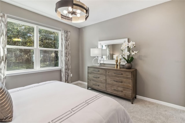 bedroom with baseboards and light carpet