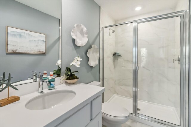 full bathroom featuring toilet, a stall shower, and vanity