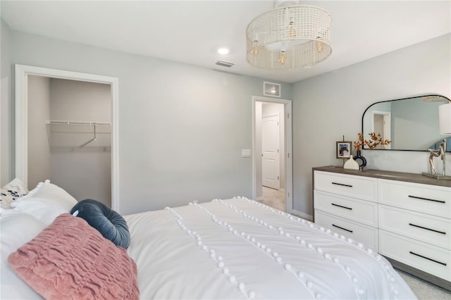 bedroom with a closet, visible vents, and a walk in closet