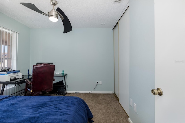 bedroom featuring ceiling fan, carpet, baseboards, and a textured ceiling