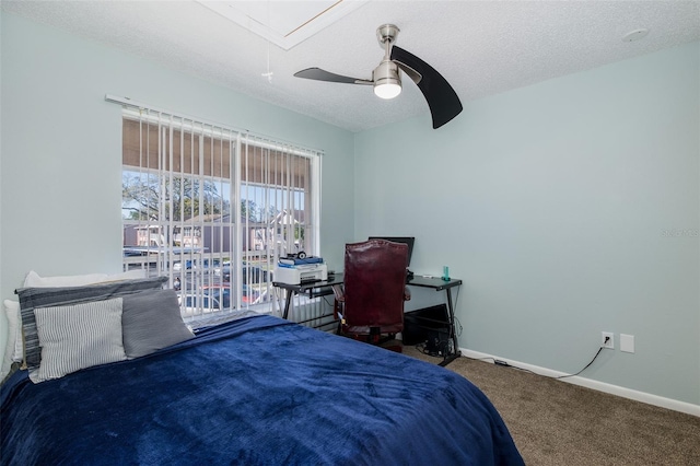 carpeted bedroom featuring baseboards, a textured ceiling, attic access, and a ceiling fan