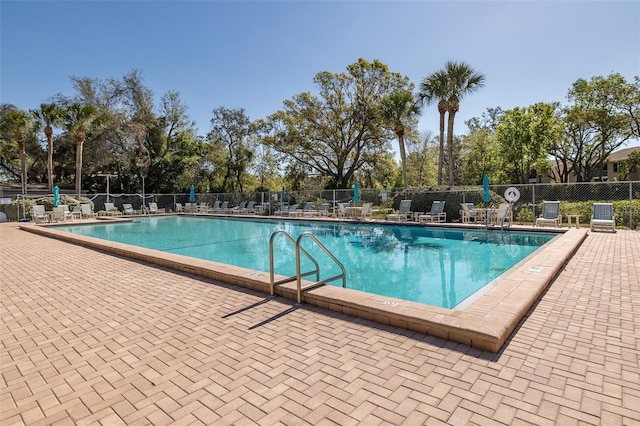 pool with a patio and fence