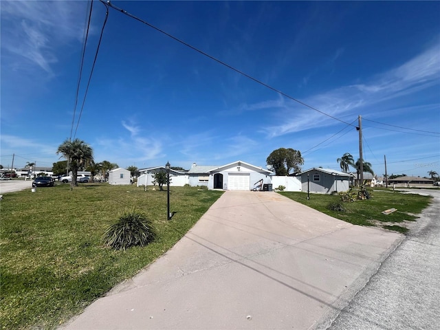 view of front facade with concrete driveway and a front yard