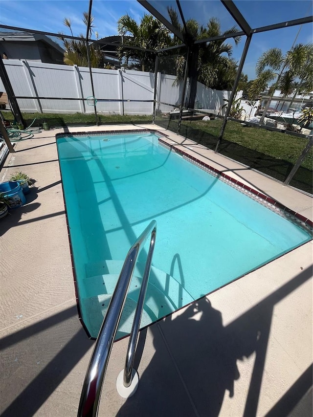 view of pool featuring glass enclosure, a patio area, fence, and a fenced in pool