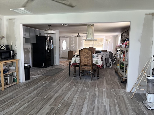 dining space with a ceiling fan, visible vents, and wood tiled floor