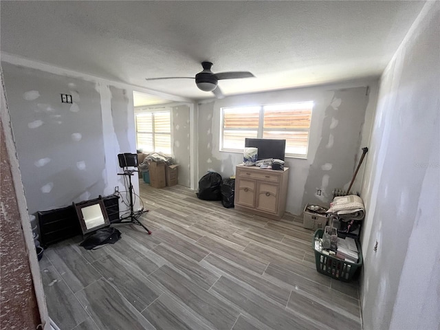 home office featuring wood tiled floor, a ceiling fan, and a textured ceiling