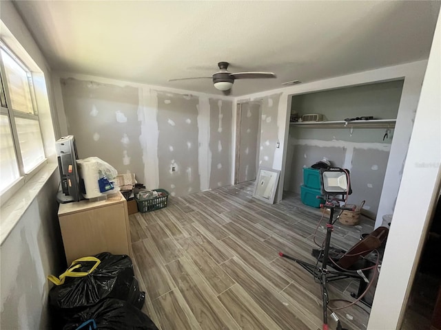 bedroom with wood finish floors, visible vents, and ceiling fan