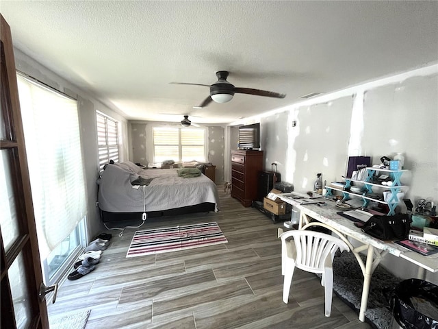 bedroom featuring a textured ceiling, wood finished floors, and a ceiling fan