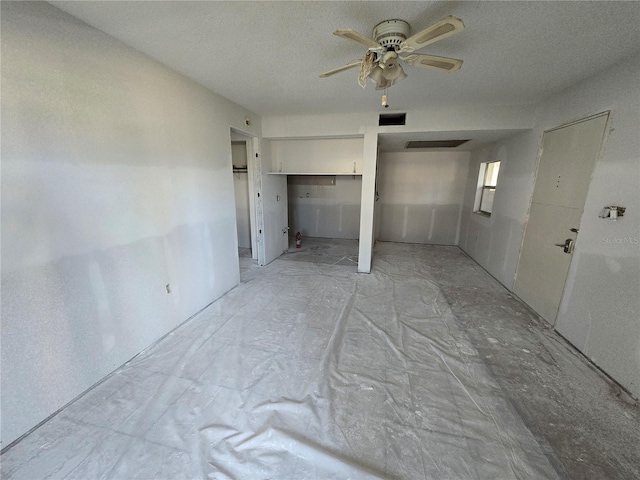 unfurnished room featuring visible vents, a textured ceiling, and a ceiling fan