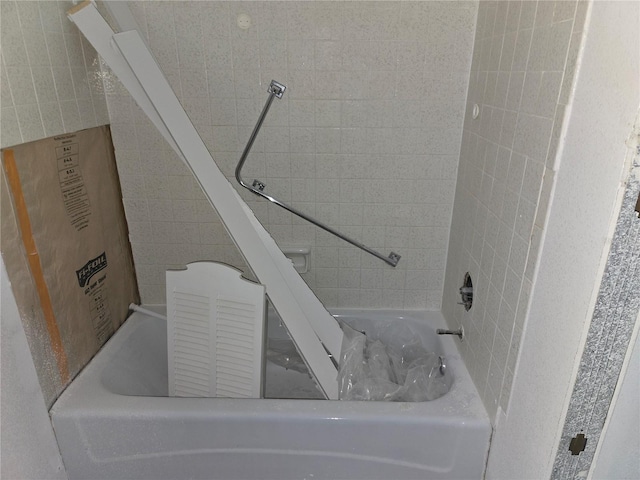 full bath featuring a bathing tub and tile walls