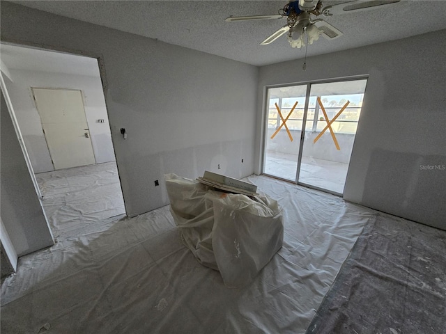 dining space featuring a ceiling fan and a textured ceiling