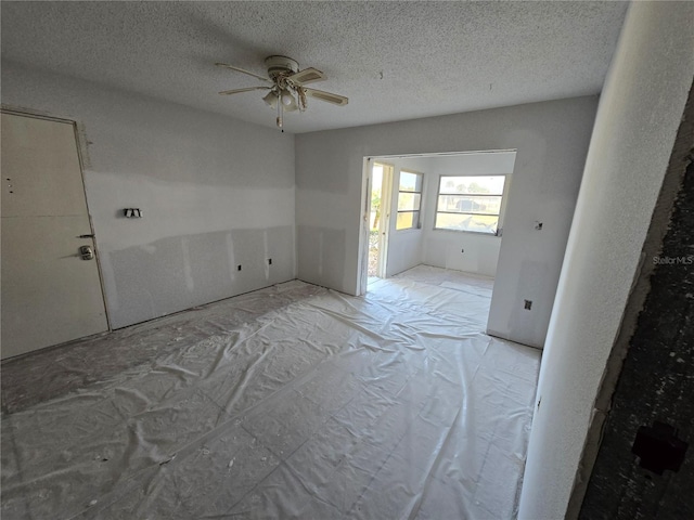 empty room featuring a textured ceiling and ceiling fan