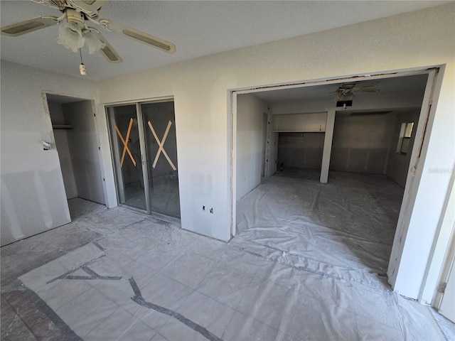 unfurnished bedroom featuring a ceiling fan and two closets