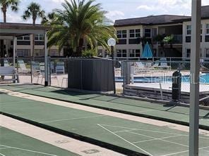 view of property's community featuring shuffleboard and fence