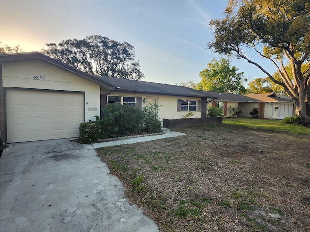 single story home featuring stucco siding, an attached garage, and driveway