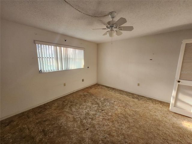 empty room with a ceiling fan, a heating unit, carpet floors, and a textured ceiling