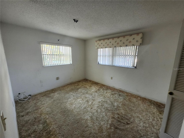 carpeted spare room featuring a textured ceiling