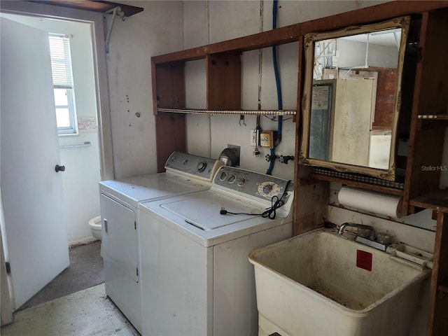 washroom with washing machine and clothes dryer, laundry area, and a sink