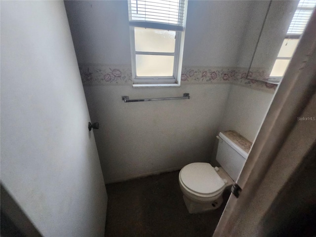 bathroom featuring a wainscoted wall and toilet