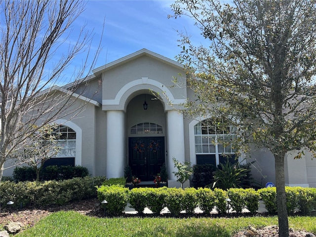 doorway to property featuring stucco siding