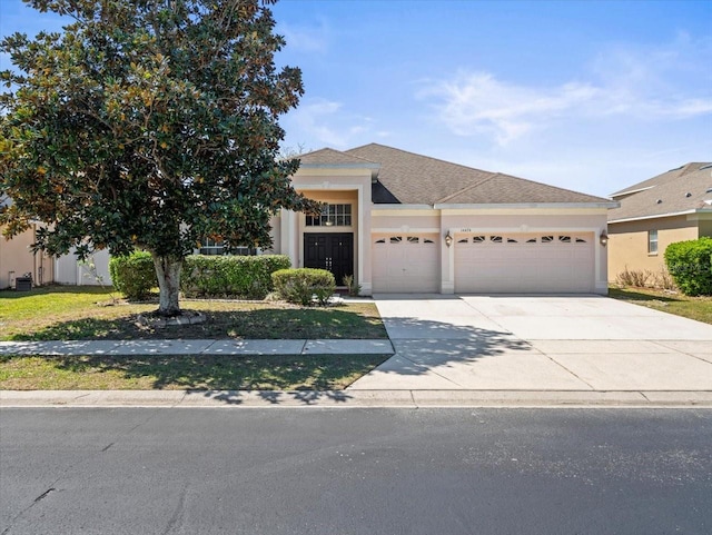 view of front of property with stucco siding, driveway, a shingled roof, and a garage