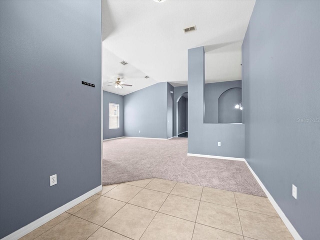 empty room featuring visible vents, baseboards, ceiling fan, carpet flooring, and arched walkways