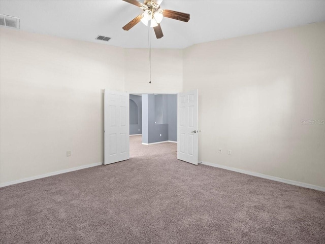 unfurnished room featuring carpet, a ceiling fan, visible vents, and baseboards