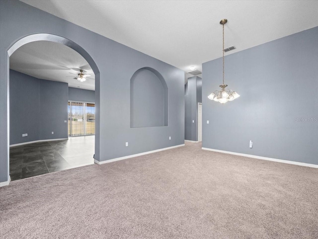 carpeted empty room with visible vents, arched walkways, baseboards, and ceiling fan with notable chandelier