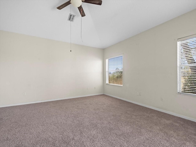 carpeted empty room featuring visible vents, baseboards, and a ceiling fan