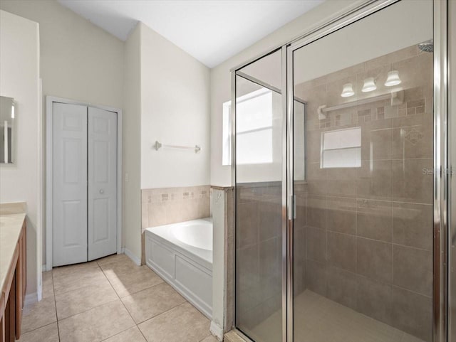 bathroom featuring vanity, a shower stall, a bath, and tile patterned flooring