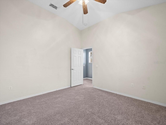 carpeted empty room with visible vents, baseboards, and a ceiling fan