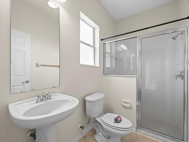 full bath with tile patterned flooring, baseboards, toilet, a stall shower, and a sink