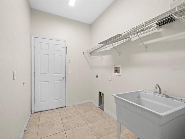 washroom with electric dryer hookup, a sink, light tile patterned flooring, hookup for a washing machine, and laundry area