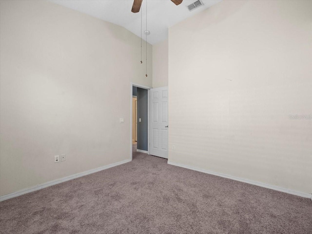 spare room with baseboards, visible vents, high vaulted ceiling, carpet floors, and ceiling fan