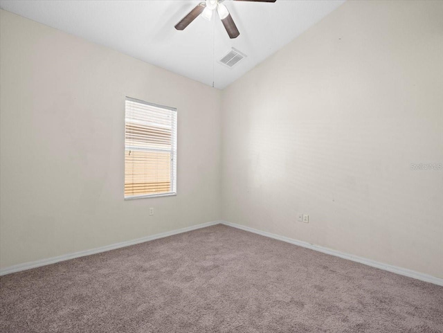 carpeted empty room with visible vents, baseboards, ceiling fan, and vaulted ceiling