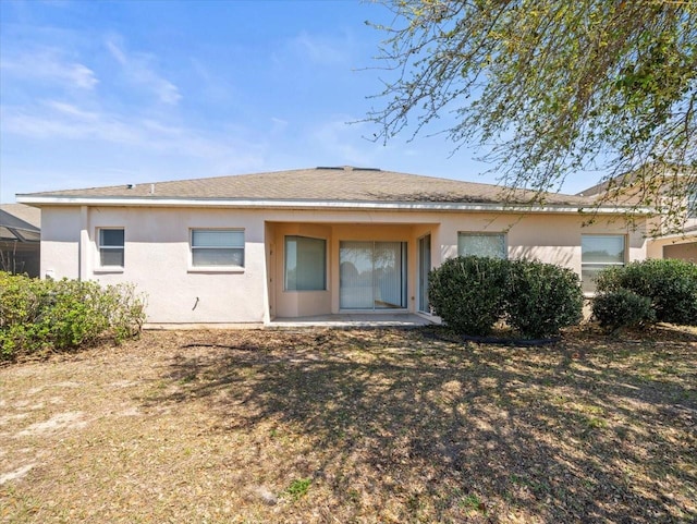 rear view of property featuring stucco siding and a patio