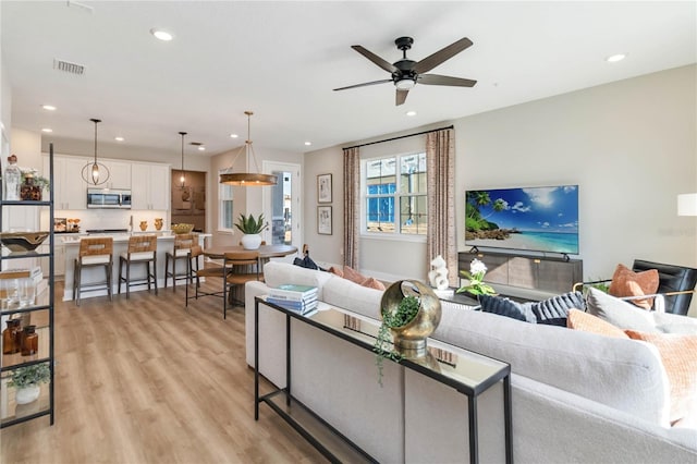 living room with light wood finished floors, visible vents, recessed lighting, and a ceiling fan