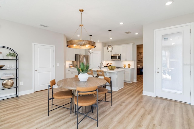 dining area featuring light wood finished floors, visible vents, recessed lighting, and baseboards