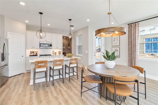 dining area featuring plenty of natural light, light wood-style floors, recessed lighting, and baseboards