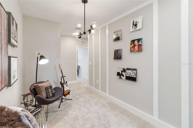 sitting room featuring light carpet, visible vents, an inviting chandelier, and baseboards