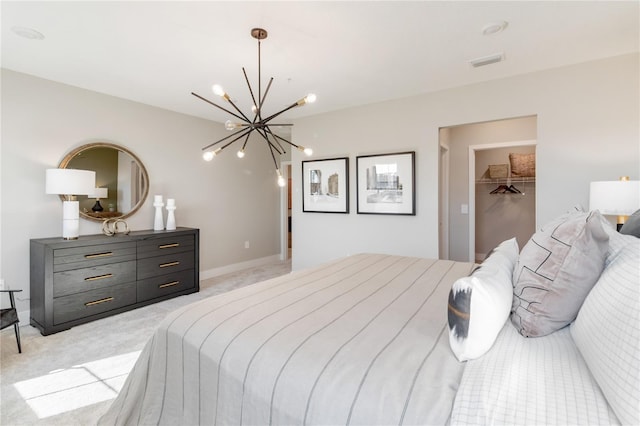 bedroom featuring visible vents, baseboards, an inviting chandelier, a walk in closet, and light colored carpet