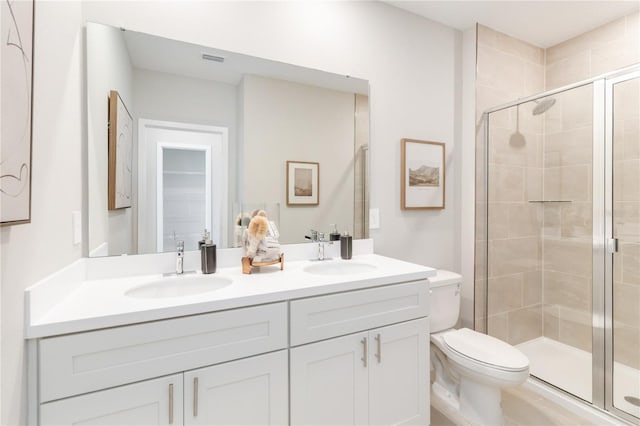 bathroom featuring a sink, toilet, and a stall shower