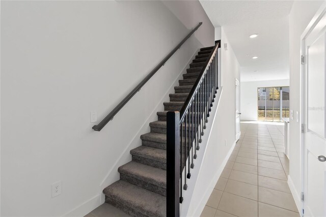 stairway featuring tile patterned floors, recessed lighting, and baseboards