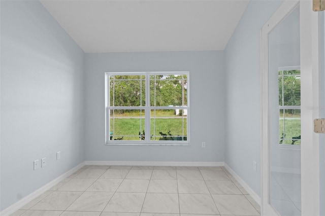 spare room featuring plenty of natural light and baseboards