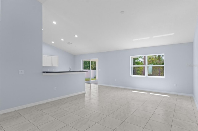 empty room featuring recessed lighting, lofted ceiling, and baseboards