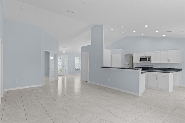 kitchen featuring visible vents, stainless steel appliances, white cabinetry, dark countertops, and open floor plan