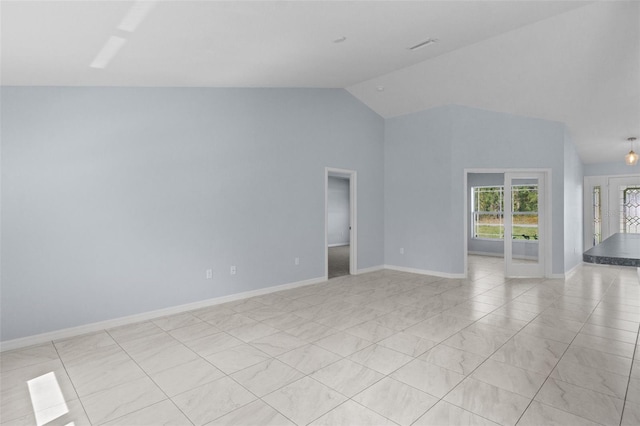 spare room with baseboards and vaulted ceiling